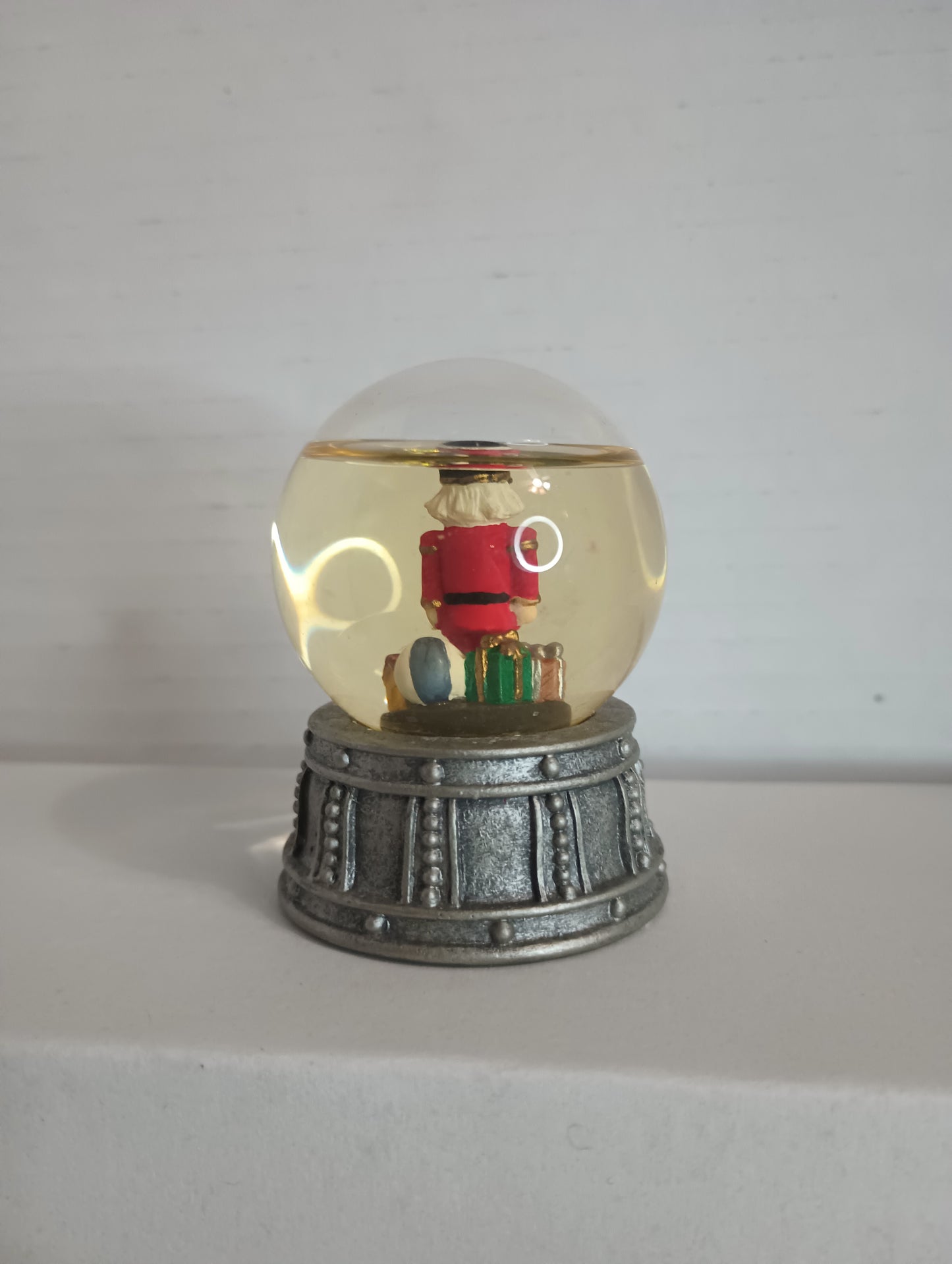 Vintage Miniature Snow Globe With Red Nutcracker and presents, ball, house On Silver Drum 2.5"